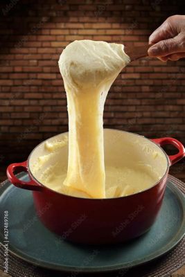  Aligot - Een romige aardappelpuree met pikante fonduekaas die je smaakpapillen zal vermaken!